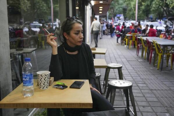 A woman sits in the alfresco dining area of a cafe at Tajrish commercial district without wearing her mandatory Islamic headscarf in northern Tehran, Iran, Saturday, April 29, 2023. More women are choosing not to wear the mandatory headscarf, or the hijab, publicly in Iran. Such open defiance of the law follows months of protests over the September death of 22-year-old Mahsa Amini while in the custody of the country's morality police, for wearing her hijab too loosely.(AP Photo/Vahid Salemi)