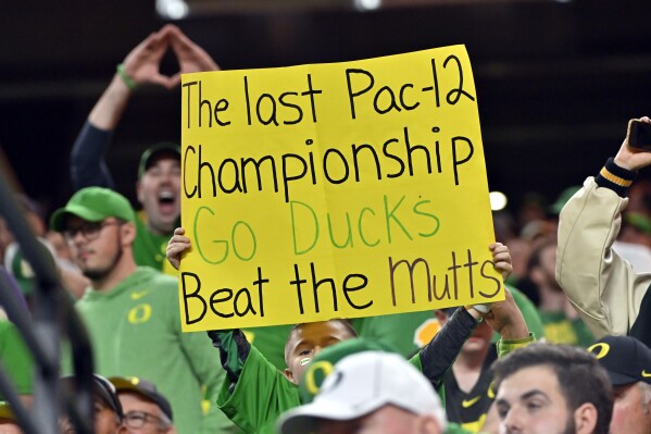 An Oregon fan waves a sign noting the final game of the Pac-12 Conference, during the second half of the Pac-12 championship NCAA college football game between Washington and Oregon on Friday, Dec. 1, 2023, in Las Vegas. (AP Photo/David Becker)