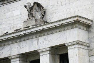 FILE - This May 22, 2020, file photo shows the Federal Reserve building in Washington. A Federal Reserve survey of U.S. business conditions has found modest economic gains at the start of the year, although some parts of the country saw slowdowns stemming from a renewed surge of COVID-19 cases. The Fed report released Wednesday, Jan. 13, 2021 said that the bulk of the Fed's 12 regions reported modest gains in economic activity in recent weeks. But two districts saw declines in activity, and another two reported little or no change. (AP Photo/Patrick Semansky, File)