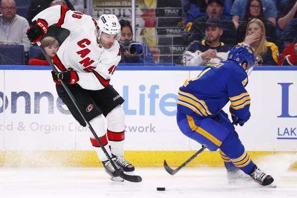 Carolina Hurricanes left wing Jordan Martinook (48) carries the puck past Buffalo Sabres defenseman Will Butcher (4) during the second period of an NHL hockey game Tuesday, April 5, 2022, in Buffalo, N.Y. (AP Photo/Jeffrey T. Barnes)