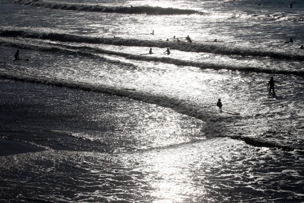 FILE - People swim in the Atlantic Ocean in Biarritz, southwestern France, Oct. 27, 2021. An abrupt shutdown of Atlantic Ocean currents that could put large parts of Europe in a deep freeze is looking a bit more likely and closer than before, according to a new story. (AP Photo/Bob Edme, File)