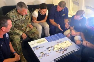
              Acting Homeland Secretary Elaine Duke, center, is briefed on the Hurricane Maria response during a flight to Puerto Rico on Friday, Sept. 29, 2017. President Donald Trump on Thursday cleared the way for more supplies to head to Puerto Rico by waiving restrictions on foreign ships delivering cargo to the island.  (AP Photo/Luis Alonso Lugo)
            
