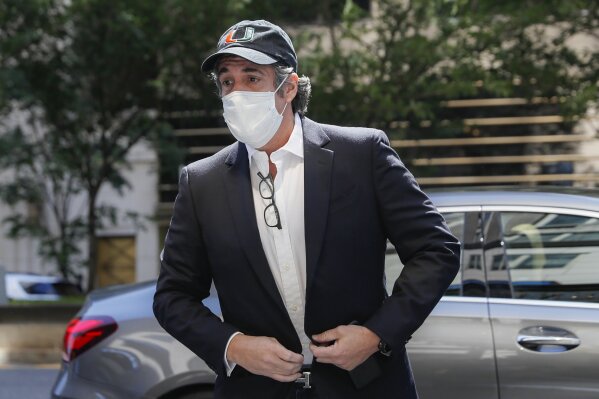 FILE- In this May 21, 2020 file photo, Michael Cohen arrives at his Manhattan apartment in New York after being furloughed from prison because of concerns over the coronavirus. Cohen was furloughed from prison along with other prisoners as authorities tried to slow the spread of the coronavirus in federal prisons. He was returned to prison on July 9, 2020 because he refused to sign an agreement over terms of his home confinement, not because he planned to publish a book critical of Trump, prosecutors said Wednesday, July 22, 2020. (AP Photo/John Minchillo, File)