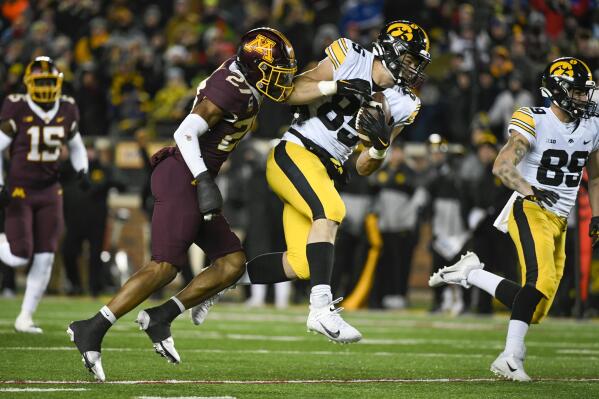 Iowa tight end Luke Lachey (85) catches a pass as he is tackled by Minnesota defensive back Tyler Nubin (27) during the second half an NCAA college football game on Saturday, Nov. 19, 2022, in Minneapolis. (AP Photo/Craig Lassig)