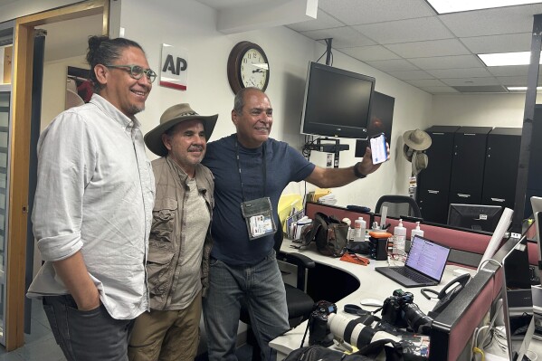 AP photographers, from left, Eduardo Verdugo, Marco Ugarte and Fernando Llano pose for photos after winning the Pulitzer for feature photography, for their images of the migration crisis, at the Associated Press office in Mexico City, Monday, May 6, 2024. Eight AP staff and freelance photographers, six from Latin America and two from the U.S., were awarded this year's Pulitzer for feature photography for images taken in 2023 that documented the anxiety, heartbreak and even the brief moments of joy that mark the migrants' journey. (AP Photo/Megan Janetsky)