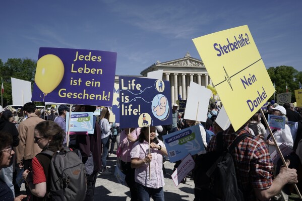 Participants in the 'March for Life' rally stand with banners reading 'Every life is a gift', 'Life is life' and 'Euthanasia no thanks' in Munich, Germany, Saturday, April 13, 2024. An independent experts commission has recommended that abortion in Germany should no longer fall under the country’s penal code and be made legal during the first 12 weeks of pregnancy. Currently, abortion is considered illegal in Germany, but not punishable if a woman undergoes mandatory counseling and a three-day wait period before she has the procedure. (Uwe Lein/dpa via AP)