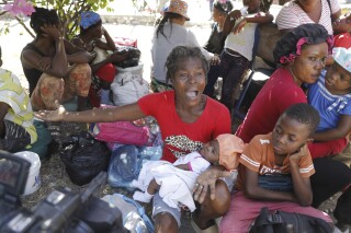 Women and children gather outside a police station after fleeing their homes in Cite Soleil due to gang violence, in Port-au-Prince, Haiti, Monday, Feb. 12, 2024. (AP Photo/Odelyn Joseph)