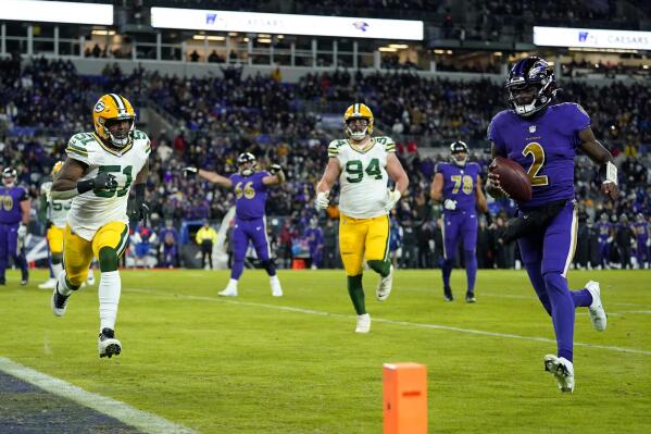 Baltimore Ravens quarterback Tyler Huntley, right, rushes for a touchdown past Green Bay Packers inside linebacker Krys Barnes (51) and defensive end Dean Lowry (94) in the second half of an NFL football game, Sunday, Dec. 19, 2021, in Baltimore. (AP Photo/Julio Cortez)