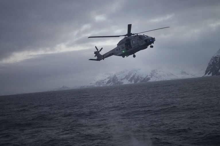 A helicopter approaching to land on the French navy frigate Normandie during a patrol in a Norwegian fjord, north of the Arctic circle, Thursday March 7, 2024. The French frigate is part of a NATO force conducting exercises in the seas, north of Norway, codenamed Steadfast Defender, which are the largest conducted by the 31 nation military alliance since the cold war. (AP Photo/Thibault Camus)