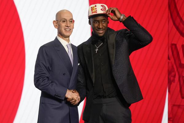 A.J. Griffin tips his cap alongside NBA Commissioner Adam Silver after being selected 16th overall by the Atlanta Hawks in the NBA basketball draft, Thursday, June 23, 2022, in New York. (AP Photo/John Minchillo)