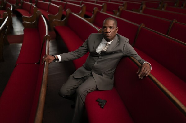 Rev. Jimmie Hardaway Jr. sits for a portrait next to the gun he carries on him during services at Trinity Baptist Church Sunday, Aug. 20, 2023, in Niagara Falls, N.Y. “I’m really not free if I have to sit here and worry about threats to a congregation,” says Hardaway, one of several religious leaders who sued New York officials last fall after lawmakers restricted guns in houses of worship. (AP Photo/David Goldman)