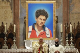 FILE - 15-year-old Carlo Acutis, an Italian boy who died in 2006 of leukemia, lies in state ahead of being beatified by Cardinal Agostino Vallini, in Assisi, Italy, on Oct. 10, 2020. Pope Francis has paved the way for the canonization of the first saint of the millennial generation on Thursday, attributing a second miracle to a 15-year-old Italian computer whiz who died of leukemia in 2006. Carlo Acutis, born on May 3, 1991, in London and then moved with his Italian parents to Milan as a child, was the youngest contemporary person to be beatified by Francis in Assisi in 2020. (AP Photo/Gregorio Borgia, File)