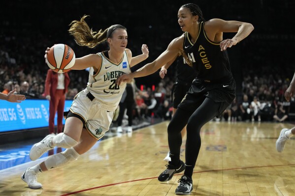 New York Liberty guard Sabrina Ionescu (20) drives against Las Vegas Aces center Kiah Stokes (41) during the first half in Game 2 of a WNBA basketball final playoff series Wednesday, Oct. 11, 2023, in Las Vegas. (AP Photo/John Locher)