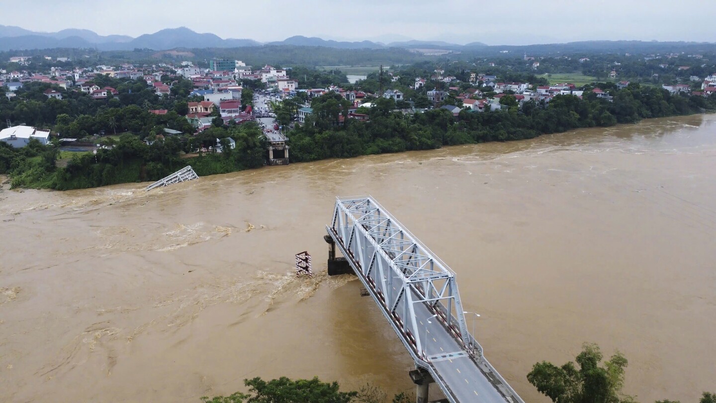 Flooding sweeps away a bus and a bridge collapses in Vietnam as typhoon deaths upward thrust to 59