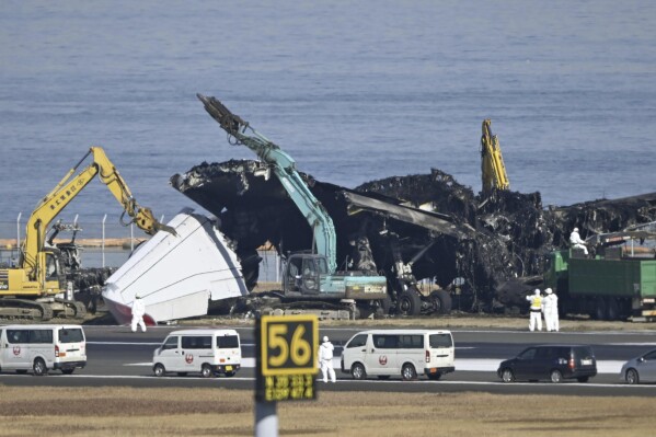 A removal work is underway at the site of a planes collision at Haneda airport in Tokyo Friday, Jan. 5, 2024. Cranes were dismantling the Japan Airlines Flight 516 Airbus A350 that caught fire after hitting a Coast Guard aircraft while it was landing Tuesday at the airport. (Kyodo News via AP)