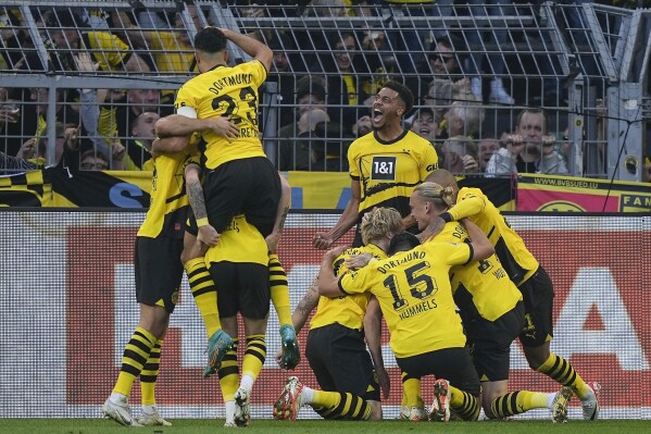 Dortmund's team celebrates Dortmund's scorer Julian Brandt who scored their side's third goal during the German Bundesliga soccer match between Borussia Dortmund and Union Berlin in Dortmund, Germany, Saturday, Oct. 7, 2023. (AP Photo/Martin Meissner)