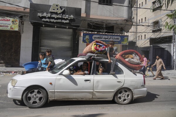 Palestinians fleeing from northern Gaza to the south with their belongings stacked on their cars after the Israeli army issued an unprecedented evacuation warning to a population of over 1 million people in northern Gaza and Gaza City to seek refuge in the south ahead of a possible Israeli ground invasion, Friday, Oct. 13, 2023. (AP Photo/Hatem Moussa)