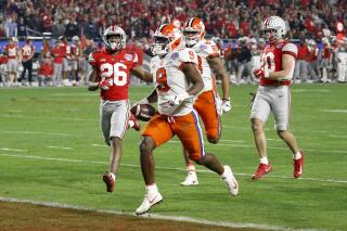 FILE - In this Dec. 28, 2019, file photo, Clemson running back Travis Etienne scores a touchdown against Ohio State during the second half of the Fiesta Bowl NCAA college football playoff semifinal, in Glendale, Ariz. Etienne was selected to The Associated Press preseason All-America first-team, Tuesday, Aug. 25, 2020.  (AP Photo/Ross D. Franklin, File)