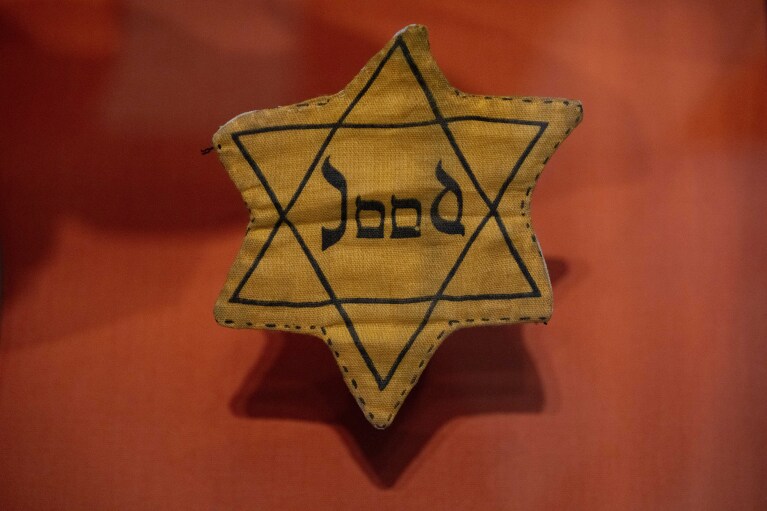 Star of David badge with Dutch word "quality"or "The Jew"worn during World War II, is on display at the new National Holocaust Museum in Amsterdam, Netherlands, Tuesday, March 5, 2024. (AP Photo/Peter Dejong)