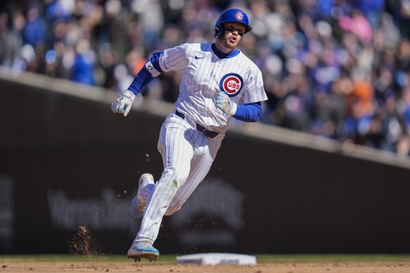 Chicago Cubs' Ian Happ runs the bases after hitting a triple during the sixth inning of a baseball game against the Los Angeles Dodgers, Friday, April 5, 2024, in Chicago. (AP Photo/Erin Hooley)