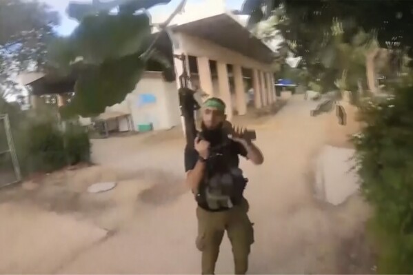 This image made from undated bodycam video footage taken by a downed Hamas militant and released by Israel Defense Forces shows a Hamas militant walking around a residential neighborhood at an undisclosed location in southern Israel. Israel's military brought together a group of foreign correspondents Monday, Oct. 16, 2023, to screen a 40-minute reel of gruesome footage compiled from the Hamas attack last week. The screening came as Israel's military faces increasing pressure to back up their claims of atrocities committed by the militants. (Israel Defense Forces via AP)