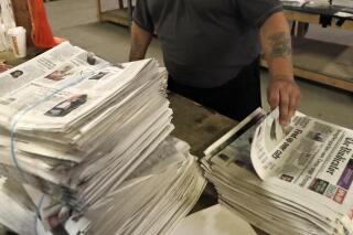 FILE - An employee sorts newspapers for delivery at a distribution center in Liberty Township near Youngstown, Ohio, on Aug. 6, 2019. Pew Research Center data released this week showed that 2020 was the first year that the newspaper industry earned more money from circulation than advertising, (AP Photo/Tony Dejak, File)