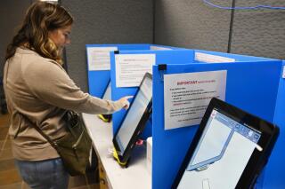 FILE - In this Tuesday, Nov. 5, 2019, file photo, Courtney Parker votes on a new voting machine in Dallas, Ga. In a ruling issued on Sunday, Oct. 11, 2020, a federal judge expressed serious concerns about the new election system but declined to immediately order the state to switch to hand-marked ballots so close to the November 2020 election. (AP Photo/Mike Stewart, File)