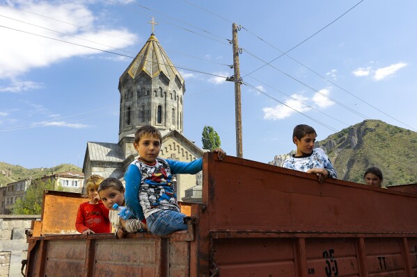 Ethnic Armenian children from Nagorno-Karabakh look from a truck after arriving in Armenia's Goris in Syunik region, Armenia, on Thursday, Sept. 28, 2023. The separatist government of Nagorno-Karabakh announced Thursday that it will dissolve itself and the unrecognized republic will cease to exist by the end of the year, and Armenian officials said more than half of the population has already fled. More than half of the region's population has already fled to Armenia, according to Armenian officials. (AP Photo/Vasily Krestyaninov)