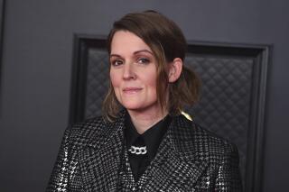FILE - In this March 9, 2021 file photo, Brandi Carlile poses on the press line at the 63rd Grammy Awards at the Los Angeles Convention Center. The award show aired on March 14 with both live and prerecorded segments. Carlile's new album “In These Silent Days” will come on Oct. 1 and is influenced by Bowie, Freddie Mercury and her two close musical friends, Elton John and Joni Mitchell. (Photo by Jordan Strauss/Invision/AP, File)