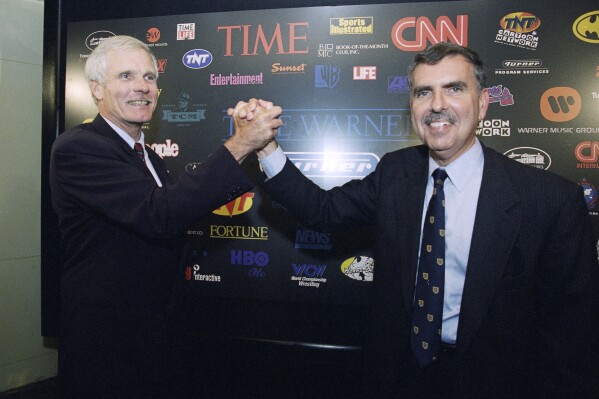 FILE - Turner Broadcasting Chairman and President Ted Turner, left, and Time Warner Chairman and CEO Gerald Levin pose for photographers prior to a news conference at the Time Life Building, Friday, Sept. 22, 1995, in New York. Levin, who led Time Warner Media into a disastrous $112 billion merger with the internet provider America Online, died Wednesday, March 13, 2024. He was 84. (AP Photo/Richard Drew, File)