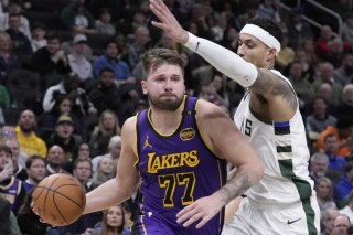 Los Angeles Lakers' Luka Doncic tries to get past Milwaukee Bucks' Kyle Kuzma during the first half of an NBA basketball game Thursday, March 13, 2025, in Milwaukee. (AP Photo/Morry Gash)