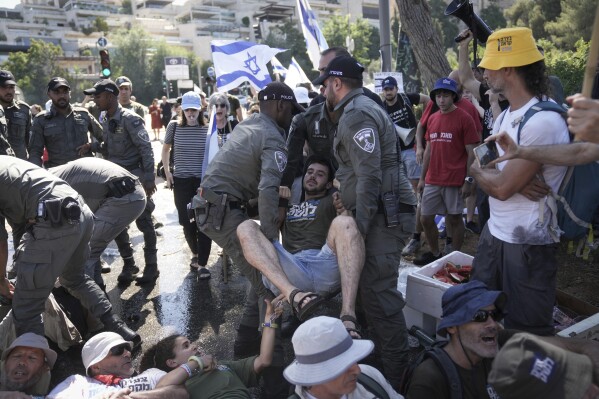 Israeli police disperse demonstrators blocking the road leading to the Knesset, Israel's parliament, during a protest against plans by Prime Minister Benjamin Netanyahu's government to overhaul the judicial system, in Jerusalem, Monday, July 24, 2023. The demonstration came hours before parliament is expected to vote on a key part of the plan. (AP Photo/Mahmoud Illean)