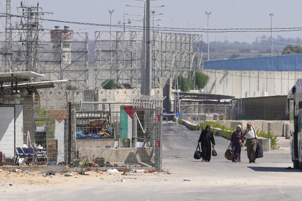 Palestinian patients carry their belongings on their way back to the Gaza Strip after receiving medical treatment in Israel, near the Erez crossing between Gaza and Israel, in the town of Beit Hanoun, northern Gaza Strip, Tuesday, Sept. 19, 2023. Israel shut down the main personnel crossing between Israel and Gaza to thousands of Palestinian laborers on Tuesday, following a resurgence of violent protests at the Israeli border fence in recent days. (AP Photo/Adel Hana)