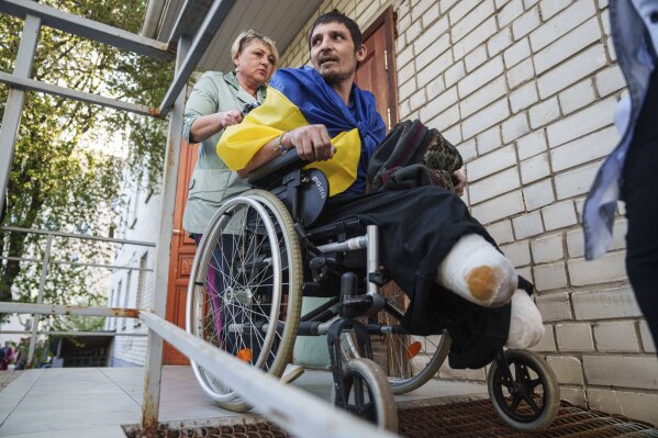 A medical worker uses a wheelchair to move an injured Ukrainian soldier from an ambulance after returning from captivity in a POW exchange in Ukraine, on Saturday, April. 19, 2025. (AP Photo/Evgeniy Maloletka)