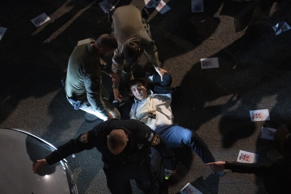 Israeli police officers disperse ultra-Orthodox Jewish men blocking a highway during a protest against army recruitment in Bnei Brak, Israel, on Jan. 9, 2025. (AP Photo/Oded Balilty, File)