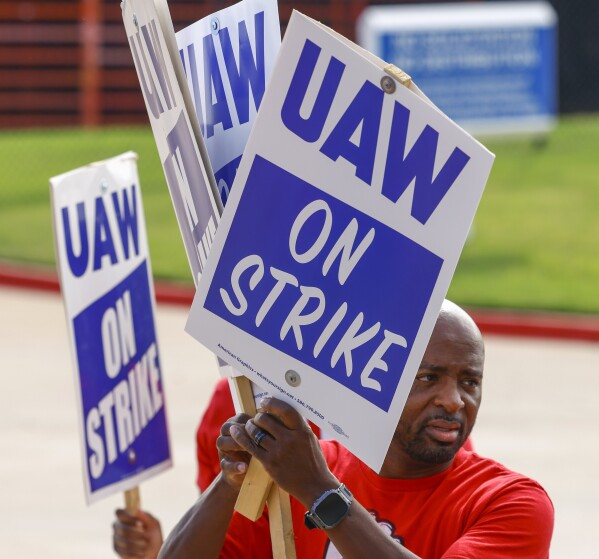 UAW local 816 president Cornelius Lincoln distributes signs to the employees ahead of a walkout on Friday, Sept. 22, 2023, at Fort Worth Parts Distribution Center in Roanoke, Texas. (Shafkat Anowar/The Dallas Morning News via AP)