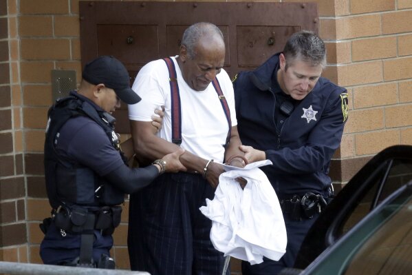 FILE - In this Sept. 25, 2018 file photo Bill Cosby is escorted out of the Montgomery County Correctional Facility, in Eagleville, Pa., following his sentencing to three-to-10-year prison sentence for sexual assault.  A Pennsylvania appeals court will hear arguments, Monday, Aug. 12, 2019,  as Cosby appeals his sexual assault conviction.  The 82-year-old Cosby is serving a three- to 10-year prison term.   (AP Photo/Jacqueline Larma, File)