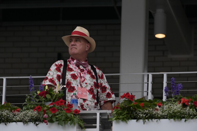 A race fan walks though the grounds of Churchill Downs before the 150th running of the Kentucky Derby horse race Saturday, May 4, 2024, in Louisville, Ky. (AP Photo/Charlie Riedel)
