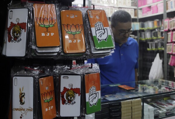 FILE- Mobile phone covers showing various political parties symbol are displayed at a wholesale shop in Mumbai, India, April 9, 2019. Misinformation about India's election is surging online as the world's most populous country votes. The country has a huge online ecosystem, with the largest number of WhatsApp and YouTube users in the world.(AP Photo/Rajanish Kakade, File)