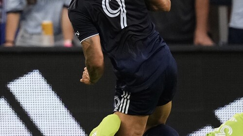 Real Salt Lake goalkeeper Gavin Beavers, bottom, blocks a goal attempt by Sporting Kansas City forward Alán Pulido (9) during the first half of an MLS soccer match Wednesday, July 12, 2023, in Kansas City, Kan. (AP Photo/Charlie Riedel)