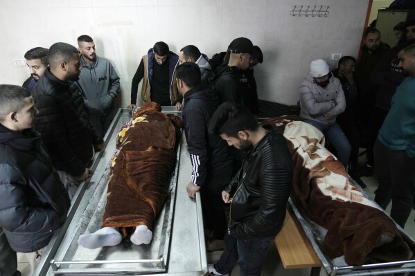Palestinian mourners bid farewell to men killed by Israeli fire in Faraa refugee camp, at the morgue in the West Bank town of Tubas, Tuesday, Feb. 27, 2024. Israeli troops shot and killed three Palestinian men including Mohammed Daraghmeh, a co-founder of the local branch of Islamic Jihad in the northern town of Tubas, early Tuesday, Palestinian health authorities said. Thee was no immediate comment from the Israeli military. (AP Photo/Majdi Mohammed)