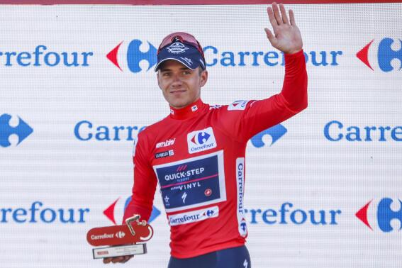 Belgian Remco Evenepoel of Quick-Step Alpha Viny celebrates on the podium in the red jersey for leader in the overall ranking after the 16th stage during the Vuelta cycling race between San Lucar de Barrameda and Tomares, in Tomares, southern Spain, Tuesday, Sept. 6, 2022. (AP Photo/Angel Fernandez)