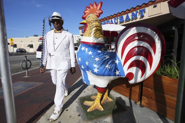 Alfredo Perez walks past a sculpture of a rooster on Calle Ocho in the Little Havana neighborhood of Miami, Wednesday, May 7, 2025. (AP Photo/Lynne Sladky)