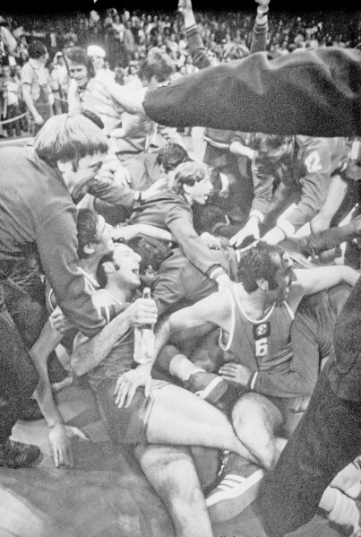 FILE - In this Sept. 10, 1972, file photo, Soviet players and supporters join in a joyous melee on the floor of the Munich Basketball Stadium, in Munich, after the Soviet team scored a 51-50 victory over the United States in the gold medal game of the Olympic basketball tournament.  (AP Photo/File)