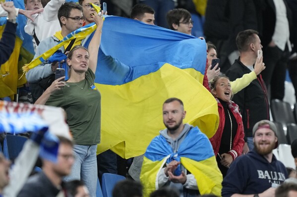 Ukraine fans wave a flag after the UEFA Champions League Group H soccer match between Shakhtar Donetsk and FC Porto in Hamburg, Germany, Tuesday, Sept. 19, 2023. (AP Photo/Martin Meissner)