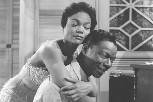 Eartha Kitt hugs Nat King Cole, playing the piano in the role of W.C. Handy, in a scene from the 1958 movie "St. Louis Blues."   (AP Photo)