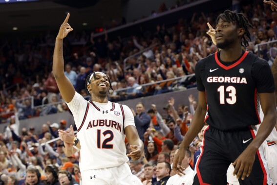 Auburn guard Denver Jones (12) reacts after making a 3-point shot over Georgia forward Dylan James (13) during the second half of an NCAA college basketball game Saturday, March 9, 2024, in Auburn, Ala. (AP Photo/ Butch Dill)