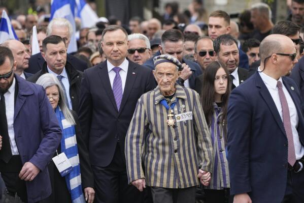 CAPTION CORRECTS THE NAME - Poland's President Andrzej Duda, centre left, and Auschwitz Survivor from U.S. Edward Mosberg, centre right, attend the March of the Living annual observance that was not held for two years due to the global COVID-19 pandemic, in Oswiecim, Poland, Thursday, April 28, 2022. Only eight survivors and some 2,500 young Jews and non-Jews are taking part in the annual march that is scaled down this year because of the war in neighboring Ukraine that is fighting Russia's invasion. (AP Photo/Czarek Sokolowski)