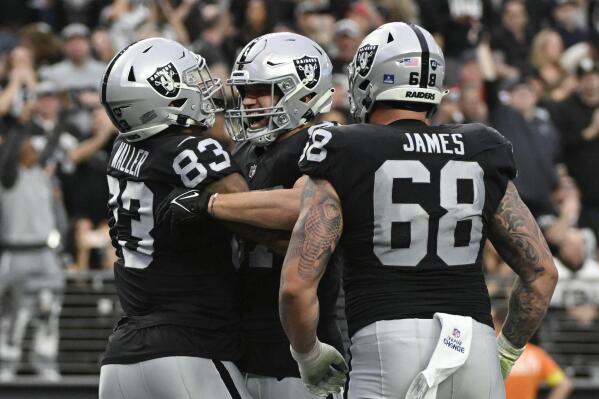 Las Vegas Raiders tight end Darren Waller (83) is congratulated by teammates after scoring on a 25-yard pass during the first half of an NFL football game between the New England Patriots and Las Vegas Raiders, Sunday, Dec. 18, 2022, in Las Vegas. (AP Photo/David Becker)