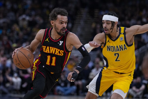 Atlanta Hawks guard Trae Young (11) drives on Indiana Pacers guard Andrew Nembhard (2) during the first half of an NBA basketball game in Indianapolis, Sunday, April 14, 2024. (AP Photo/Michael Conroy)